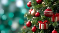 Festive Christmas tree decorated with red and gold ornaments, wrapped gifts, and twinkling lights against a soft teal bokeh background.