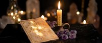 Mystical tarot cards with burning candle and amethyst crystals on dark surface creating atmospheric fortune telling scene for spiritual guidance.