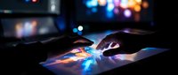 Hands touching digital tablet screen with colorful light effects and bokeh background in dark environment for modern technology and innovation concepts.