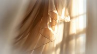 Sheer beige curtain with sunlight streaming through, creating soft shadows and warm golden light. Suitable for home decor, interior design, and lifestyle content.
