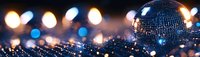 Shiny disco ball with blurred bokeh lights on dark background creating festive nightclub atmosphere.