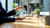 Businessman hands protecting glowing recycling symbol at modern office desk promoting environmental sustainability and green business practices.