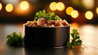 Canned tuna chunks with fresh parsley garnish in black bowl against warm bokeh lights background, moody food photography composition for healthy eating.