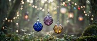 Three colorful glass Christmas ornaments hanging from chains with festive bokeh lights creating magical holiday atmosphere for seasonal decorations.