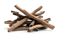 Aromatic cinnamon sticks arranged in crossed pattern on white background, dried brown spice quills isolated for culinary and seasonal designs.