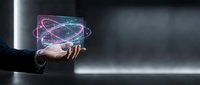 Businessman hand holding holographic atom model with glowing orbital rings in futuristic digital interface for science technology presentations.