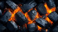Burning charcoal embers with bright orange glowing cracks between black pieces, creating dramatic contrast of fire and darkness in macro photography.