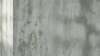 Weathered concrete wall texture with natural aging patterns and subtle stains creating an industrial urban backdrop for modern design projects.