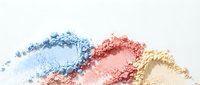 Colorful crushed eyeshadow powder makeup cosmetics in blue pink and gold shades scattered on white background for beauty and fashion design.