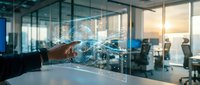 Professional hand touching futuristic holographic interface with digital network connections in modern office environment at sunset.