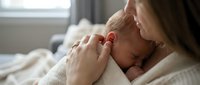 Tender moment of Caucasian mother holding sleeping newborn baby in soft natural light. Intimate maternal bonding scene perfect for parenting and healthcare content.