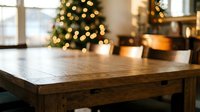 Empty wooden table surface with blurred Christmas tree lights and warm home interior background for holiday product display and festive decoration mockups.