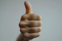 Close-up view of a thumbs up hand gesture against neutral background showing approval, agreement and positive feedback in minimalist style.