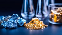 Raw gold and copper nuggets on dark background with laboratory glassware, showcasing precious metals and minerals in scientific research setting.