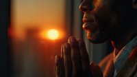 African American man praying with hands together during golden hour sunset, spiritual meditation and faith concept for religious content.