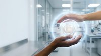 Hands protecting glowing digital circle with concentric rings in modern office environment representing data security and business protection concepts.