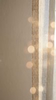 Sheer curtains in neutral tones with woven texture detail, allowing soft natural light to filter through with warm bokeh effect, suitable for home decor and interior design projects.