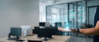 Modern office worker using holographic digital interface technology with futuristic data visualization and connectivity icons in contemporary workspace.