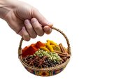 Hand holding wicker basket filled with colorful aromatic spices and seasonings isolated on white background for culinary design projects.