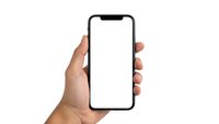 Hand holding modern smartphone with blank white screen isolated on white background for mockup and app presentation purposes.