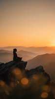 Woman meditating on mountain peak at sunrise with layered hills and warm golden sky creating peaceful mindfulness moment for wellness and spiritual practice.