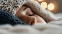 Peaceful sleeping close up with soft bokeh lights in background, cozy winter atmosphere with knitted blanket and warm glow for wellness and relaxation concepts.