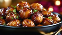 Glazed roasted chestnuts with herbs in dark bowl, festive holiday side dish with warm golden bokeh lights background for seasonal cooking and dining.