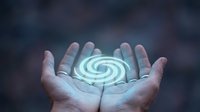 Hands holding glowing spiral energy symbol representing power, innovation, and technology solutions for business and digital transformation concepts.