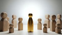 Golden figure stands out among wooden people representing leadership excellence and unique talent in business teamwork concept.