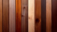 Vertical wooden planks in various natural brown tones and wood grain textures create rustic background pattern. Decorative timber surface shows different species.