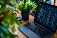 Modern workspace with laptop showing programming code on screen, surrounded by green plants creating natural atmosphere. Ideal for tech and lifestyle content.