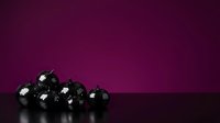 Black ornaments with silver accents arranged on reflective surface against deep purple background, suitable for holiday marketing, seasonal greeting cards, and festive design projects.