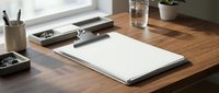 Clean minimalist workspace with blank paper notebook on wooden desk near window for creative writing and business planning projects.