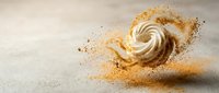 Swirling cream dessert with golden cinnamon powder explosion on neutral background for culinary and food photography projects.