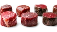 Raw beef steaks cut into thick round portions showing marbled texture and rich red color isolated on white background for culinary designs.
