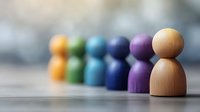 Colorful wooden peg people figures in row with one standing out from group representing leadership, diversity, teamwork and individuality concepts.