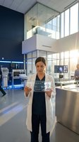 Female scientist in white lab coat analyzing transparent digital interface in modern research laboratory with advanced medical technology equipment.