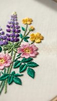 Delicate hand embroidered floral bouquet with colorful wildflowers on cream fabric showcasing traditional needlework craftsmanship and textile art techniques.