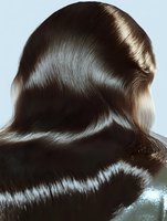 Luxurious dark brown hair waves flowing with glossy shine and smooth texture, photographed from behind showing professional salon styling and healthy hair care results.