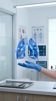 Gloved hand presenting holographic lungs in modern medical office with anatomical charts and digital displays for healthcare technology concepts.