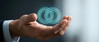 Businessman holding glowing digital wedding rings hologram symbol representing marriage partnership commitment and union concepts for relationship services.