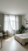 Bright, minimalist bedroom with sheer linen curtains framing large windows, wooden chair, potted plants, and neutral bedding. Scandinavian interior design for home decor and lifestyle content.