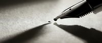 Close-up of fountain pen nib touching paper surface with dramatic lighting and shadows, perfect for writing, business, education and creative content.