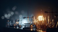 Laboratory glassware and equipment on dark background with warm lighting creating atmospheric bokeh effects for scientific research concepts.