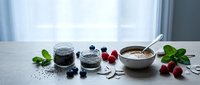 Healthy breakfast setup with chia seeds, fresh berries, and oatmeal bowl on white wooden table near window for nutritious morning meal preparation.