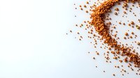 Scattered red lentils forming curved line pattern on white background, raw organic legumes spread creating minimalist food composition for healthy eating concept.