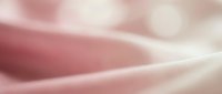 Soft pink and white fabric with gentle folds and flowing curves, creating an abstract textile background suitable for design, wellness, and beauty projects.