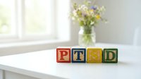 PTSD wooden blocks on white table with fresh flowers and window light, suitable for mental health awareness, psychology articles, and wellness content.