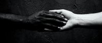 Two hands touching in support and connection against dark textured background, representing unity, compassion, and human connection for healthcare, counseling, or community themes.