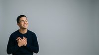 Man with hand on chest expressing gratitude, appreciation or positive emotion against neutral background. Suitable for business, wellness and lifestyle content.